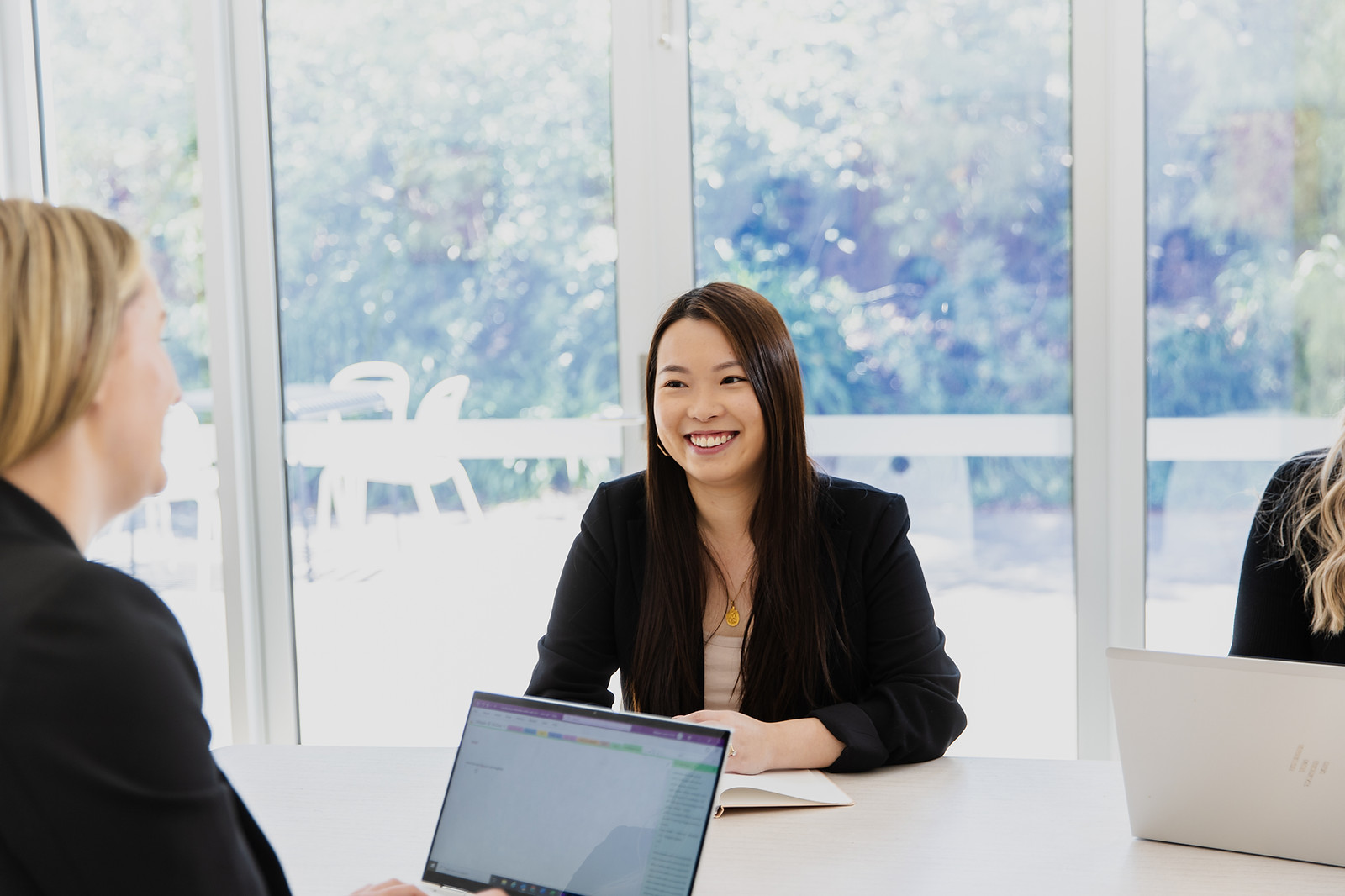 An employee at a table working with colleagues smiling