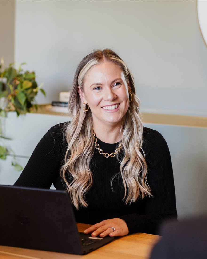 Jess Hedley, founder of People Experience Partners, smiling at her laptop